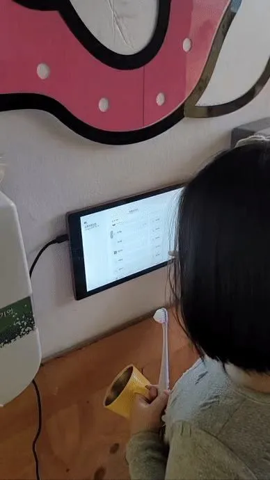 체크인 모니터 앞에서 양치하는 아이